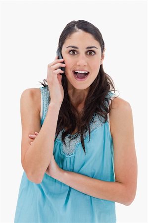 simsearch:400-05717347,k - Portrait of an amazed woman making a phone call against a white background Photographie de stock - Aubaine LD & Abonnement, Code: 400-05898416