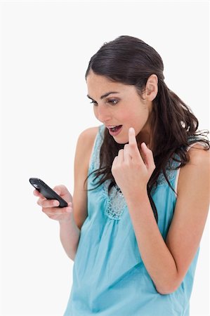 simsearch:400-06632132,k - Portrait of an amazed woman reading a text message against a white background Stock Photo - Budget Royalty-Free & Subscription, Code: 400-05898421