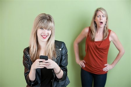 simsearch:400-05918419,k - Upset mom with happy teen on mobile phone Stock Photo - Budget Royalty-Free & Subscription, Code: 400-05898847