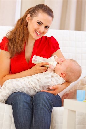 simsearch:400-05899085,k - Smiling young mother sitting on couch and feeding baby Foto de stock - Super Valor sin royalties y Suscripción, Código: 400-05899107