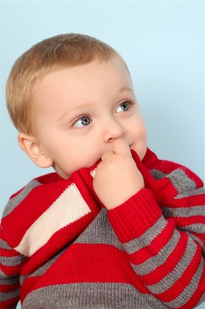 shy baby - Cute blond baby wearing a red jersey against blue Stock Photo - Budget Royalty-Free & Subscription, Code: 400-05890885