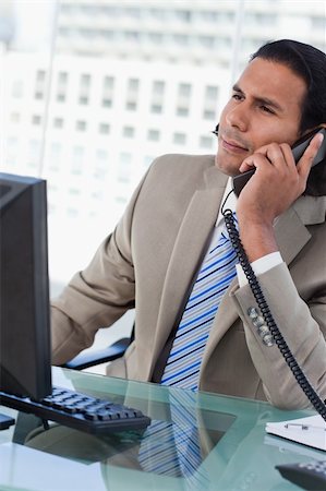 simsearch:859-06710917,k - Portrait of a handsome businessman working with a monitor while being on the phone in his office Stock Photo - Budget Royalty-Free & Subscription, Code: 400-05892345