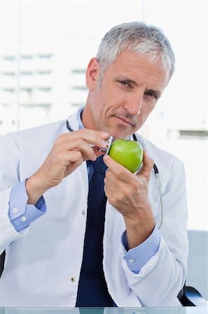 food specialist - Portrait of a doctor putting his stethoscope on an apple in his office Photographie de stock - Aubaine LD & Abonnement, Code: 400-05892408