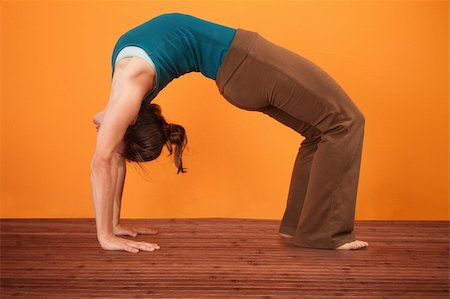Young woman performs upward bow posture over orange background Photographie de stock - Aubaine LD & Abonnement, Code: 400-05907910