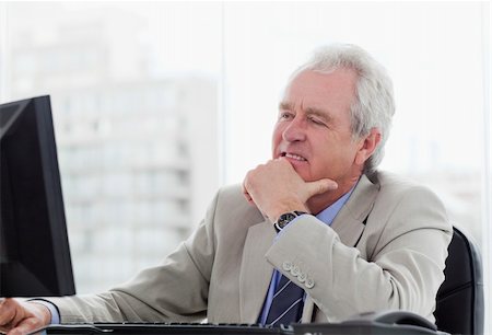 simsearch:400-05145011,k - Happy senior manager working with a monitor in his office Stock Photo - Budget Royalty-Free & Subscription, Code: 400-05900803