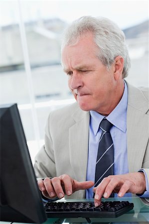 simsearch:400-05145011,k - Portrait of a serious senior manager using a computer in his office Stock Photo - Budget Royalty-Free & Subscription, Code: 400-05900814