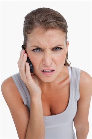 simsearch:400-05717420,k - Portrait of a confused woman making a phone call against a white background Stock Photo - Budget Royalty-Free & Subscription, Code: 400-05901035