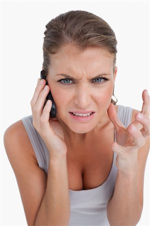 simsearch:400-05717347,k - Portrait of an angry woman making a phone call against a white background Photographie de stock - Aubaine LD & Abonnement, Code: 400-05901036