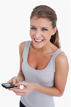 simsearch:400-05717347,k - Portrait of a happy woman holding her mobile phone against a white background Photographie de stock - Aubaine LD & Abonnement, Code: 400-05901039
