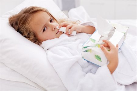 Little girl with bad cold in bed - using nasal spray and paper napkins Stock Photo - Budget Royalty-Free & Subscription, Code: 400-05919449