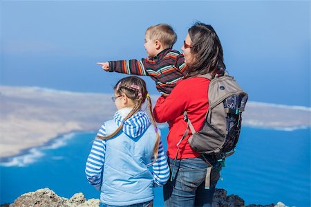 Young mother with backpack and her child standing on cliff's edge and looking to a island. Stock Photo - Budget Royalty-Free & Subscription, Code: 400-05919649