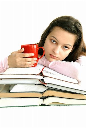 caucasian teenage girl sitting at the desk with stack of opened books and tea cup Stock Photo - Budget Royalty-Free & Subscription, Code: 400-05919685