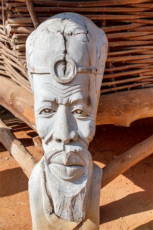 face of a tribal man - African carved wooden statue in front of dwelling Stock Photo - Budget Royalty-Free & Subscription, Code: 400-06064100