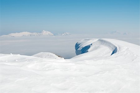 Wave shaped snowdrift. Mountains in the background. Blue sky. Julian Alps, Slovenia. Karavanke mountain range in the background. Stock Photo - Budget Royalty-Free & Subscription, Code: 400-06065620