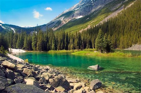 rocky mountains lakes and rivers - emerald lake at the foot of  the mountains in Sabwatcha canyon,Canada Stock Photo - Budget Royalty-Free & Subscription, Code: 400-06065801