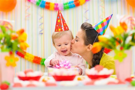 Mother kissing her happy while baby checking present Stock Photo - Budget Royalty-Free & Subscription, Code: 400-06067055