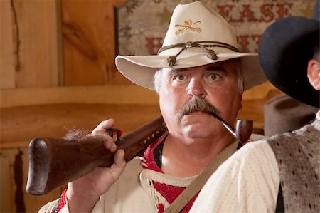 An old west fur trapper shoulders his rifle with a pipe in his mouth. Stock Photo - Budget Royalty-Free & Subscription, Code: 400-06061043