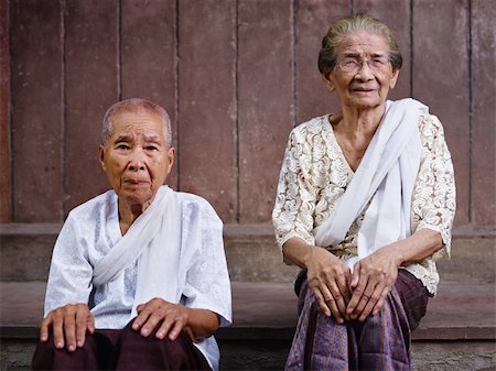 simsearch:400-07221782,k - Portrait of two old asian women sitting against brown wall and looking at camera Stock Photo - Budget Royalty-Free & Subscription, Code: 400-06061424