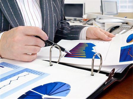 Businesswoman analyzing investment charts at his workplace Stock Photo - Budget Royalty-Free & Subscription, Code: 400-06062368