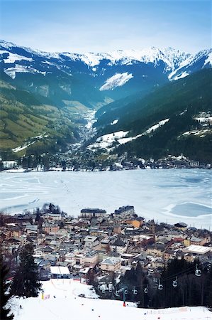 snowy austria village - Aerial view down on Zell Am See (Austria, Alpes) town, frozen lake, ski resort and mountains in fog. Stock Photo - Budget Royalty-Free & Subscription, Code: 400-06063480