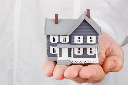 property sale - Close-up photograph of a miniature house in a man's hand. Stock Photo - Budget Royalty-Free & Subscription, Code: 400-06075742