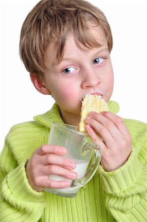 dreaming about eating - portrait of an elementary age boy eating cake and drinking milk Stock Photo - Budget Royalty-Free & Subscription, Code: 400-06078830