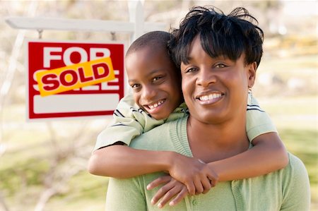 Happy African American Mother and Child In Front of Sold Real Estate Sign. Foto de stock - Super Valor sin royalties y Suscripción, Código: 400-06072953