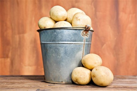 simsearch:400-05744489,k - Old bucket filled with potatoes against a rustic background Stock Photo - Budget Royalty-Free & Subscription, Code: 400-06085296