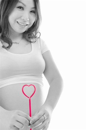simsearch:400-05716366,k - Pregnant woman holding red heart to the abdomen Stock Photo - Budget Royalty-Free & Subscription, Code: 400-06083640
