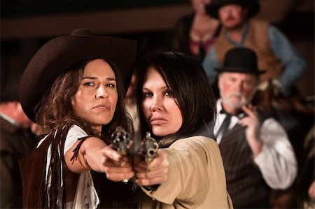 Two pretty cowgirls point revolvers at the camera Stock Photo - Budget Royalty-Free & Subscription, Code: 400-06097065