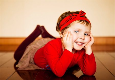 plump girls - Pretty girl in red jacket with a bow on her head lying on the floor and laughs pressed palms to her cheeks Stock Photo - Budget Royalty-Free & Subscription, Code: 400-06091489