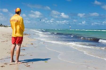 young man  life saver  watching the situation on the sea Stock Photo - Budget Royalty-Free & Subscription, Code: 400-06091587