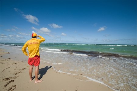 young man  life saver  watching the situation on the sea Stock Photo - Budget Royalty-Free & Subscription, Code: 400-06091591