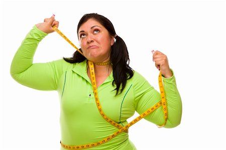 Attractive Frustrated Hispanic Woman Tied Up With Tape Measure Against a White Background. Stock Photo - Budget Royalty-Free & Subscription, Code: 400-06092919