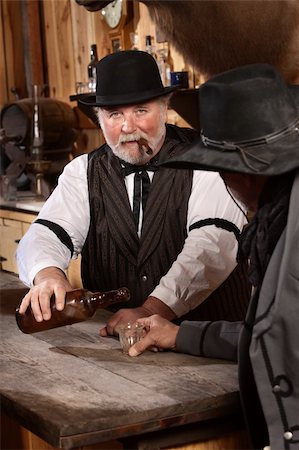 Serious bartender with cigar pours drink for customer Stock Photo - Budget Royalty-Free & Subscription, Code: 400-06104096