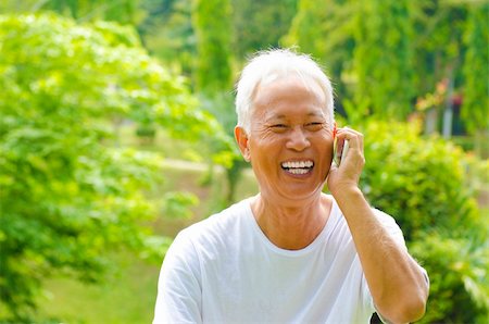 phone one person adult smile elderly - Healthy senior Asian man on the phone outdoor green park Stock Photo - Budget Royalty-Free & Subscription, Code: 400-06107315