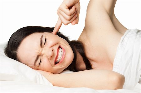 A tired, frustrated, sleepless, pretty woman putting her finger in her ear to block out disturbing noises.  Isolated over white Stock Photo - Budget Royalty-Free & Subscription, Code: 400-06108678