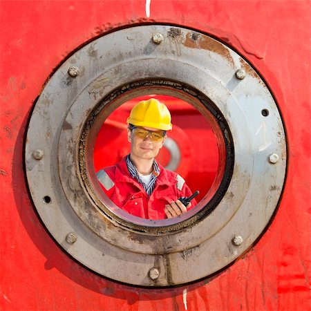 Engineer, looking to the huge bearing of a steel megastructure with a cb-radio in his hand Stock Photo - Budget Royalty-Free & Subscription, Code: 400-06137760