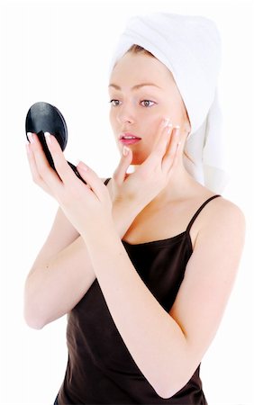 simsearch:400-06137898,k - Young woman with white tower and nice manicure is appling cream on her face and looking in the looking glass, on white background Foto de stock - Super Valor sin royalties y Suscripción, Código: 400-06137898