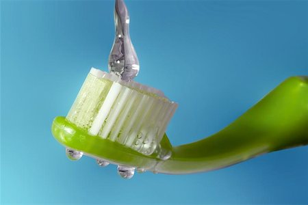 simsearch:400-04151137,k - a green toothbrush isolated against a light blue background is catching a drop of water! Photographie de stock - Aubaine LD & Abonnement, Code: 400-06130001