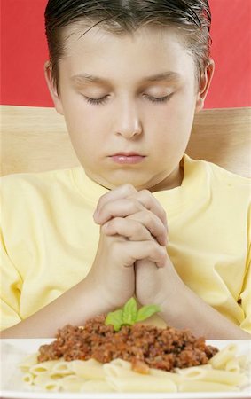 A boy with hands clasped giving thanks before a meal Stock Photo - Budget Royalty-Free & Subscription, Code: 400-06131233