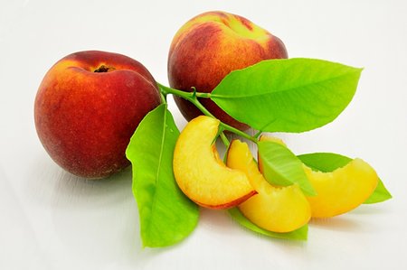 simsearch:400-05664137,k - Fresh peach slices, peach and green leaves Stock Photo - Budget Royalty-Free & Subscription, Code: 400-06174140