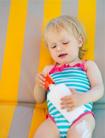 Baby laying on sun bed with sun block bottle Stock Photo - Budget Royalty-Free & Subscription, Code: 400-06174301