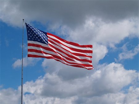 simsearch:400-06389956,k - The US American red, white and blue flag flying in front of a blue cloudy sky. Photographie de stock - Aubaine LD & Abonnement, Code: 400-06176325