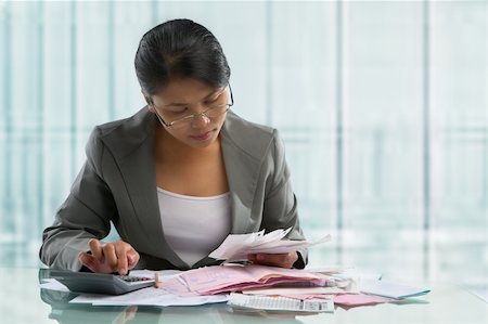 Asian businesswoman calculating pile of bills in the office Stock Photo - Budget Royalty-Free & Subscription, Code: 400-06177966