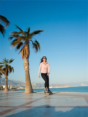 Woman enjoying a sunny afternoon on a beach promenade Stock Photo - Budget Royalty-Free & Subscription, Code: 400-06179051