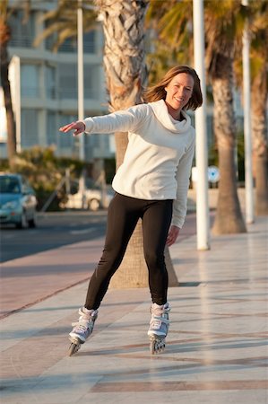 Happy and active woman skating o a sunny promenade Stock Photo - Budget Royalty-Free & Subscription, Code: 400-06179053