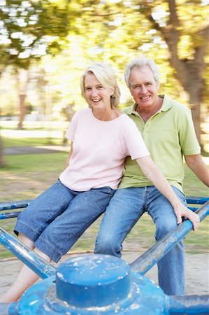 simsearch:400-04035087,k - Senior Couple Riding On Roundabout In Park Stock Photo - Budget Royalty-Free & Subscription, Code: 400-06204249