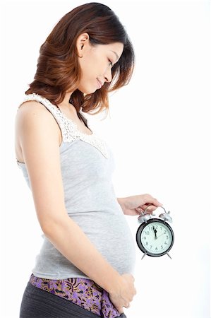 simsearch:400-04396054,k - asian Pregnant woman holding alarm clock isolated on white Stock Photo - Budget Royalty-Free & Subscription, Code: 400-06201767