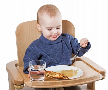 young child eating in high chair isolated in white backgound Stock Photo - Budget Royalty-Free & Subscription, Code: 400-06203111